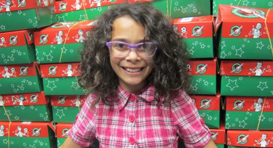 Project director Adilynn woods poses with the completed shoeboxes. Project director Adilynn woods poses with the completed shoeboxes.