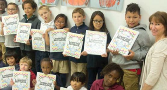 Richmond Academy first- and second-graders hold The Leader in Me notebooks, alongside teacher Karen Van Ornam. Richmond Academy first- and second-graders hold The Leader in Me notebooks, alongside teacher Karen Van Ornam.