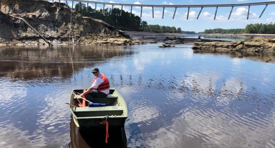 Tracy Hendren, Savannah District Engineering Division Chief, traverses the water to inspect the washout of Boiling Springs Dam, N.C. Sept. 19 after Hurricane Florence. The object stretching across the divide is the guard rail of the road that once passed over the dam. (U.S. Army Corps of Engineers photo) Tracy Hendren, Savannah District Engineering Division Chief, traverses the water to inspect the washout of Boiling Springs Dam, N.C. Sept. 19 after Hurricane Florence. The object stretching across the divide is the guard rail of the road that once passed over the dam. (U.S. Army Corps of Engineers photo)