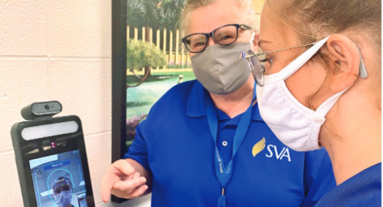 School nurse Trixi Johnson checks senior Natalie Cook’s temperature, a required protocol for daily entrance. School nurse Trixi Johnson checks senior Natalie Cook’s temperature, a required protocol for daily entrance.