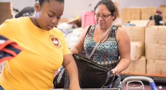 A volunteer distributes clothing at the World Harvest Outreach church in Houston. Photo by Keith Goodman A volunteer distributes clothing at the World Harvest Outreach church in Houston. Photo by Keith Goodman