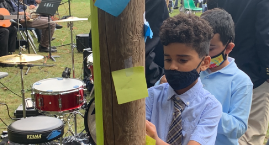 Third-graders Lucas Saintil and Hector Flores post prayer requests on a cross. Third-graders Lucas Saintil and Hector Flores post prayer requests on a cross.